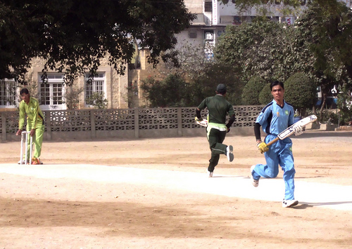 three people play cricket