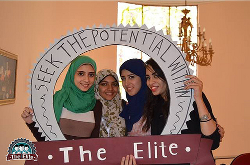 Four young women smile in a sign that says "Seek the Potential Within"