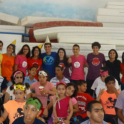 Alumni in Tunisia wear red YES shirts and smile with young kids