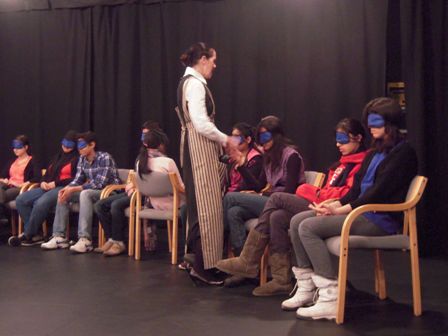 youth sit in chair blindfolded during an activity 