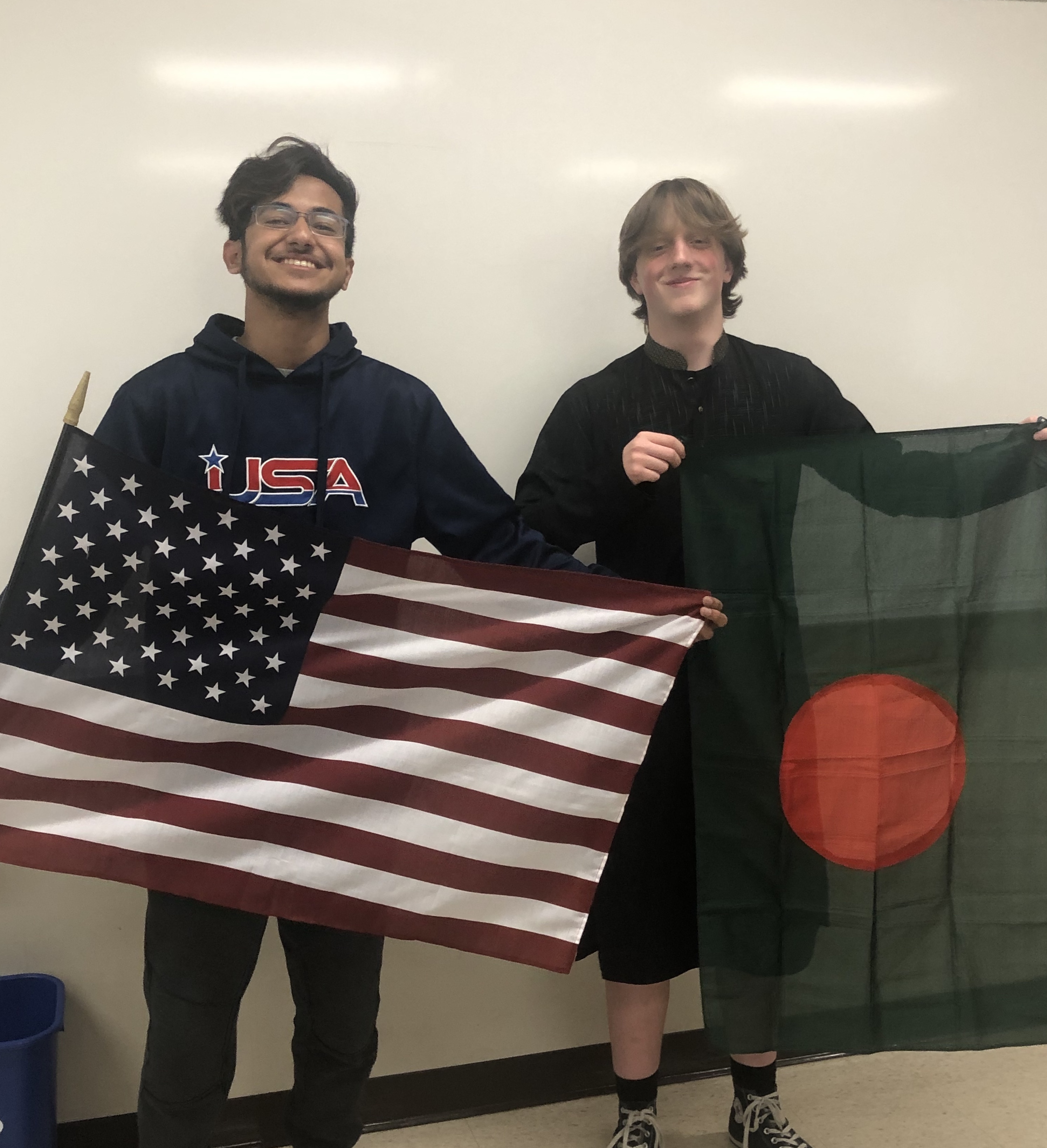 Prottay and friend holding American and Bangladeshi flags