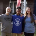 Alum Poses With Host Family Waving