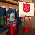 Intan Ringing A Bell Next To The Salvation Army Bucket Outside Of A Store