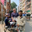 Kennedy poses with alum in rickshaw, along with rickshaw driver