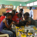 Students Gather Around A Laptop In A Classroom