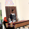 Alumni stand in front of a group of people in an auditorium and give a presentation for International Education Week. 