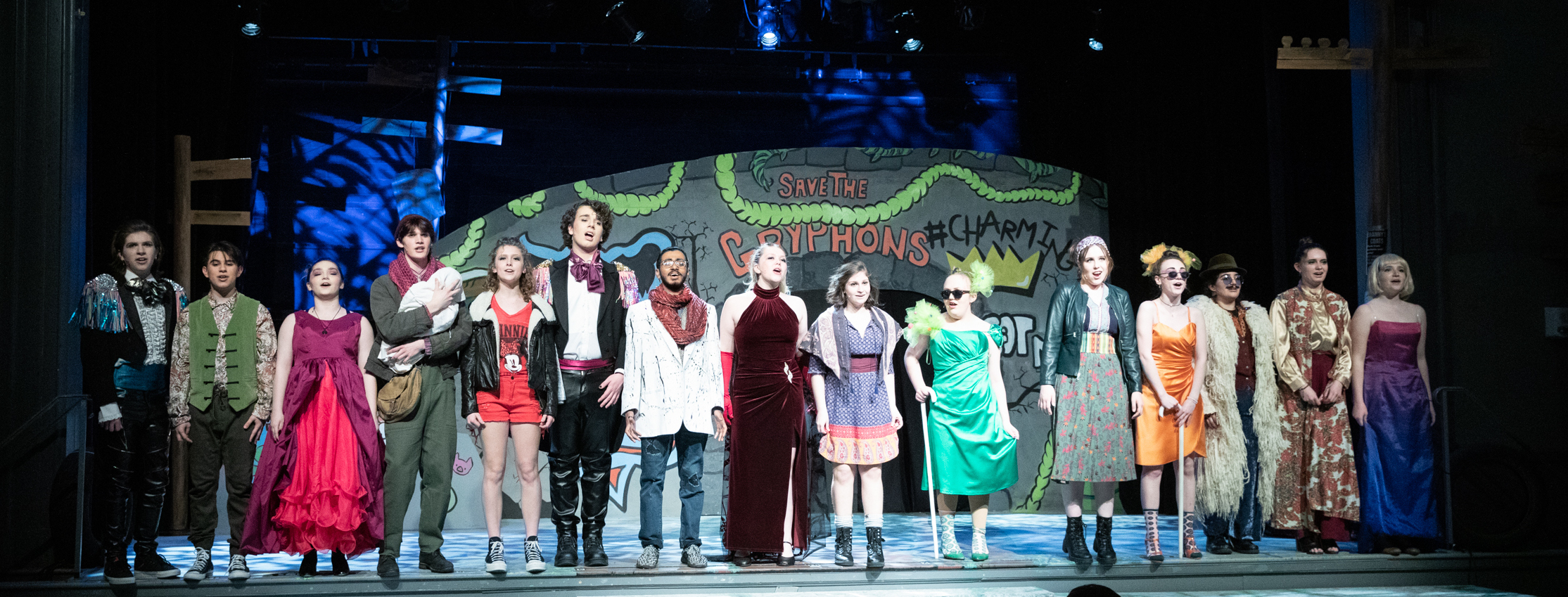 The entire cast on stage with bright costumes on