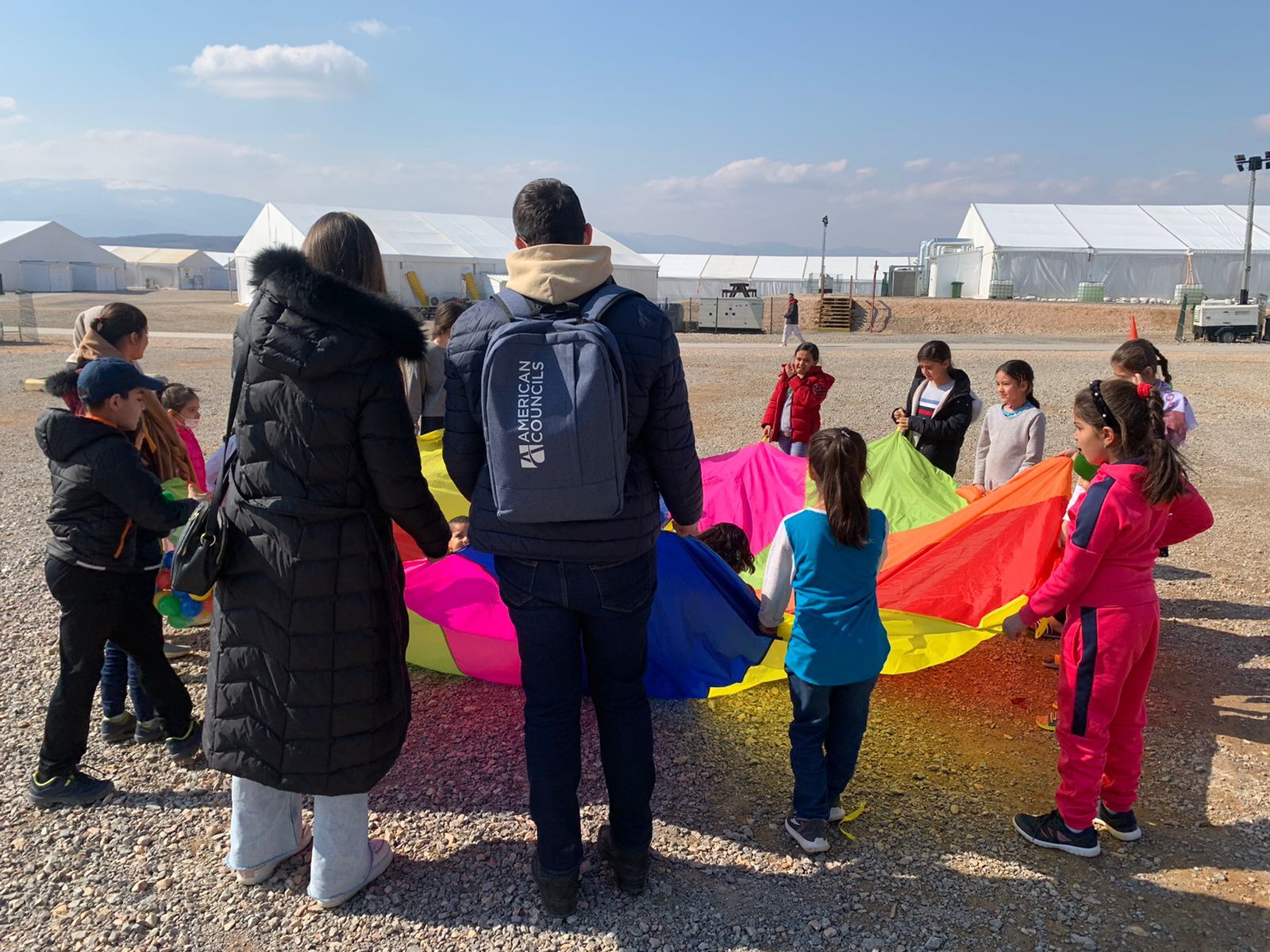 Adults and children hold a parachute
