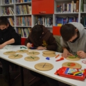 Three participants draw X's and O's on paper plates