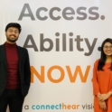 ConnectHear Cofounders stand in front of a banner