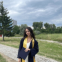Viktoria Panayotova stands in her graduation cap and gown