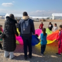 Adults and children hold a parachute