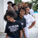 High school students in a line smiling and wearing "Say her name" tshirts