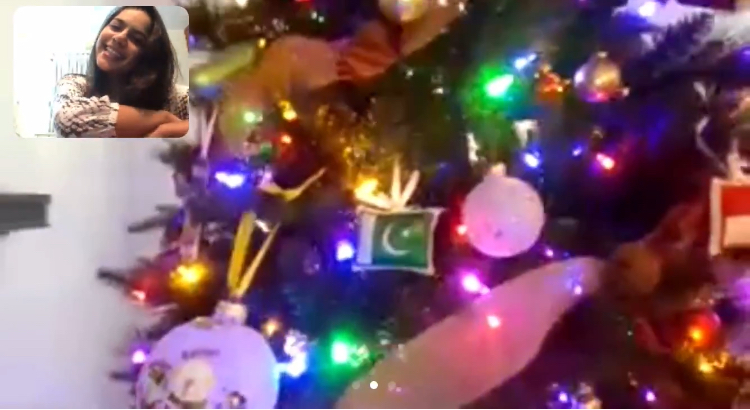 Zainub on a video call while her host family shows her the different ornaments. 