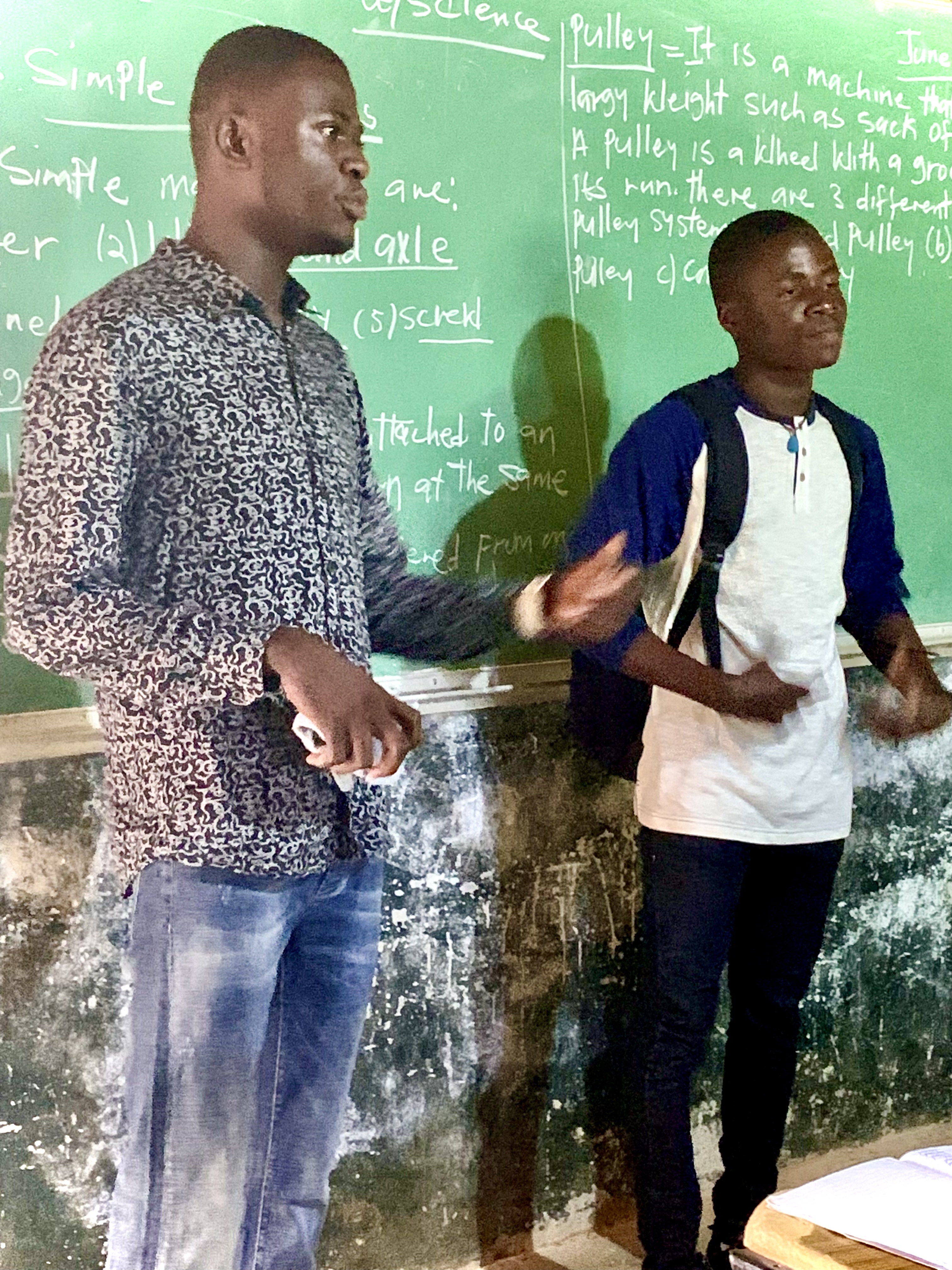 Melvin standing at the front of a classroom with another student.  Jpeg 1