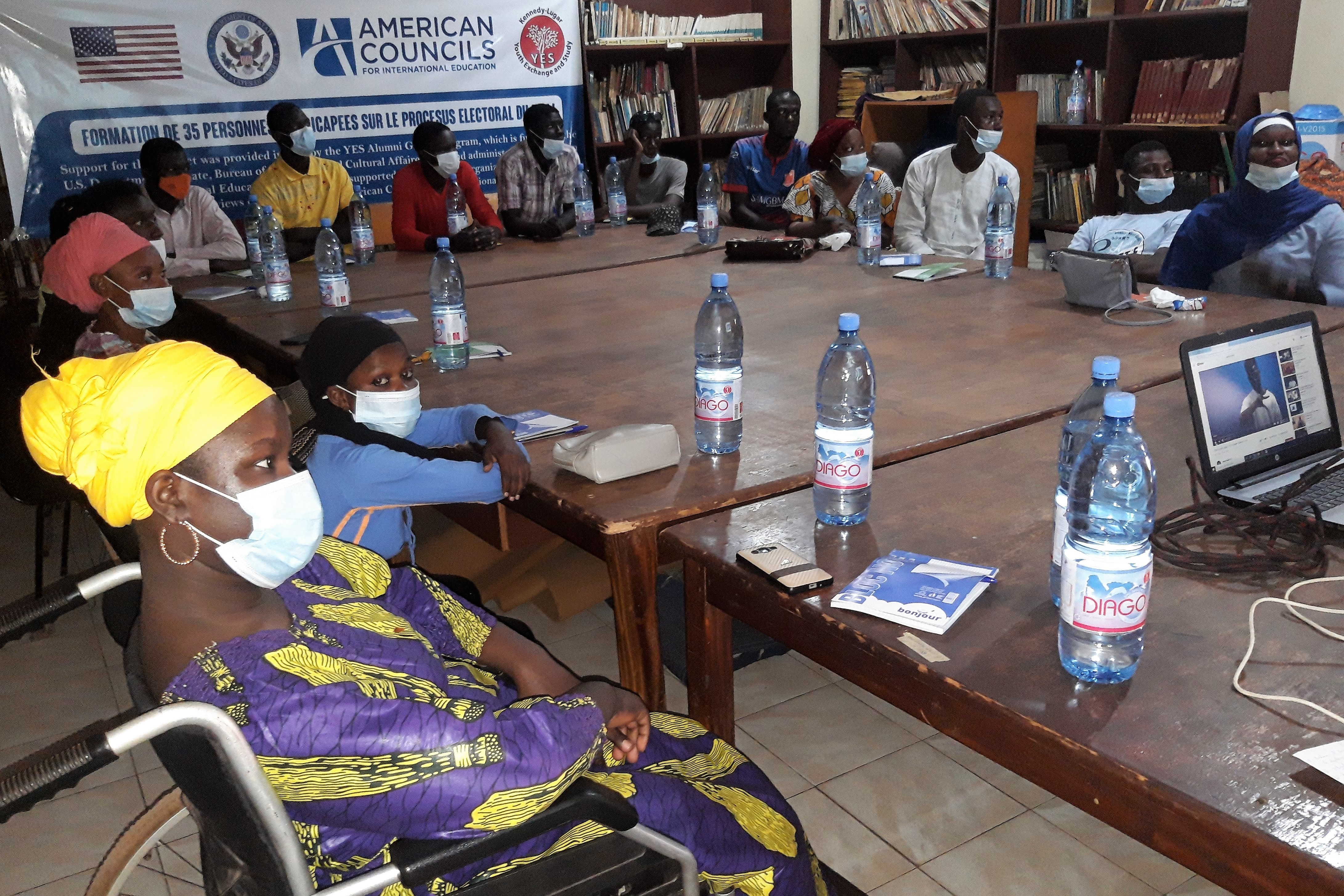 Participants sit around a conference table learning about elections in Mali