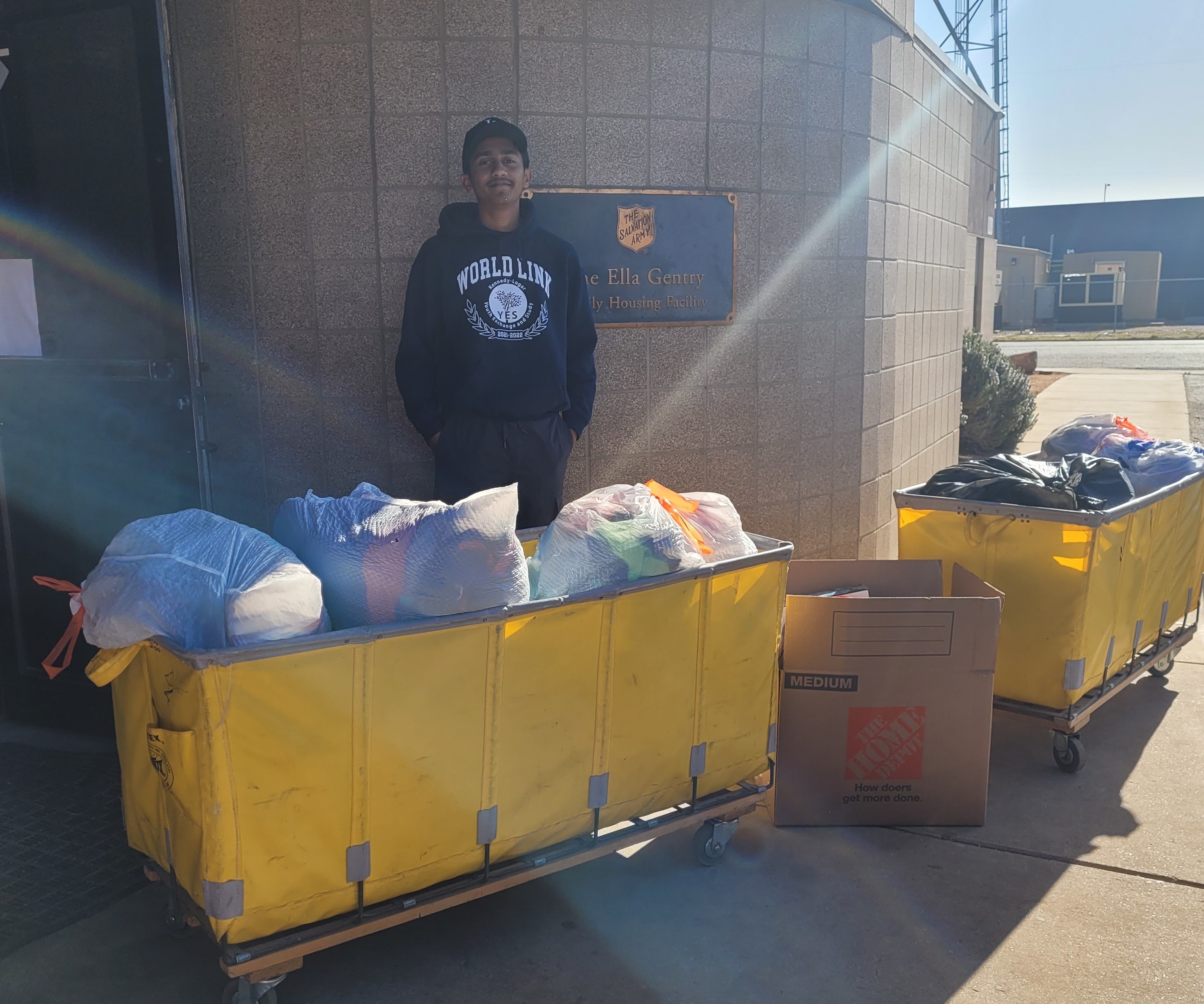 Ashfaque at Salvation Army with donation bins full of clothes and toys. . 