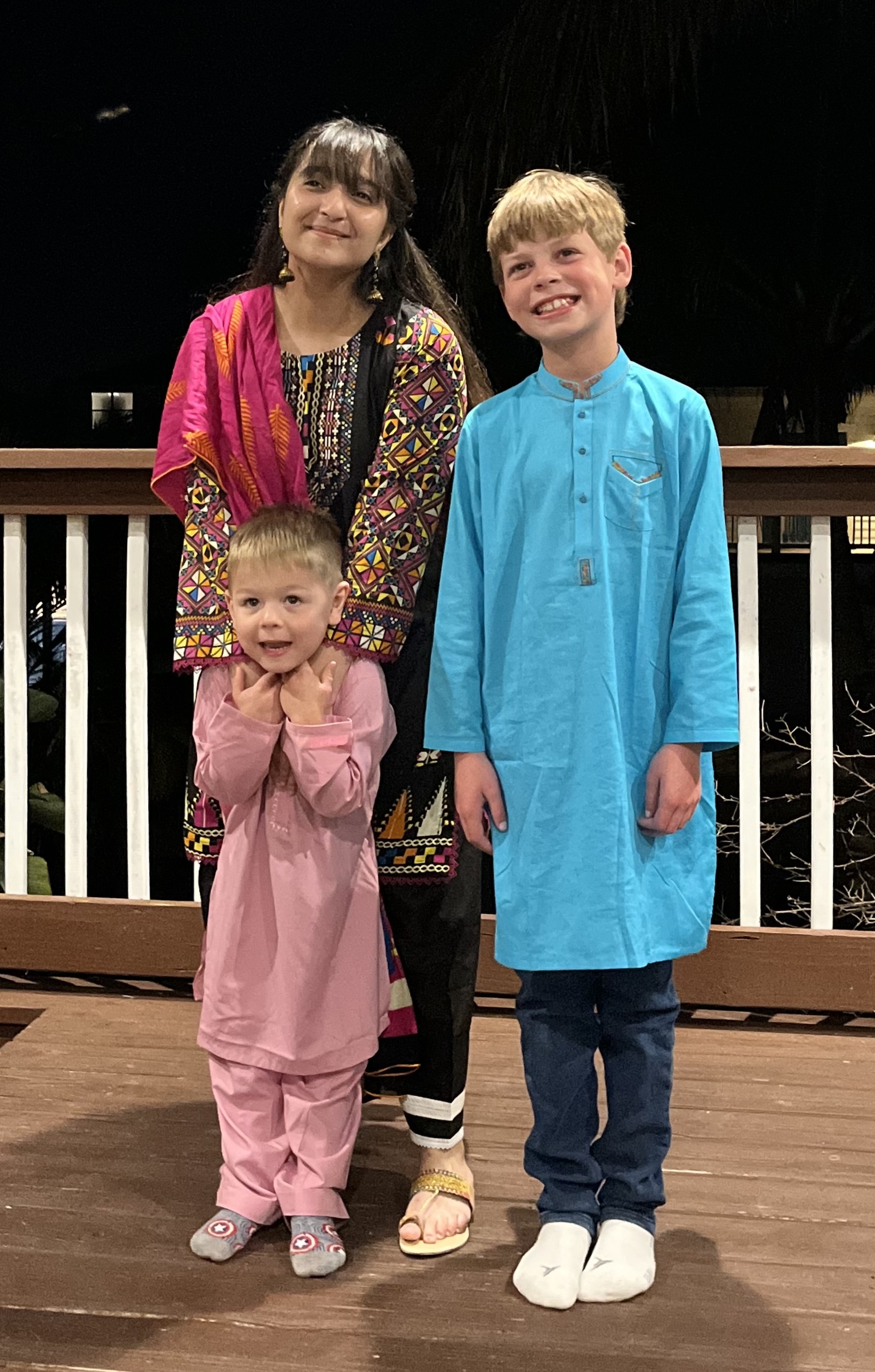Mahnoor and two host siblings smiling on a deck