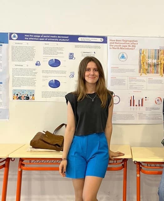 Duresa poses in front of a research poster she created and presented. 