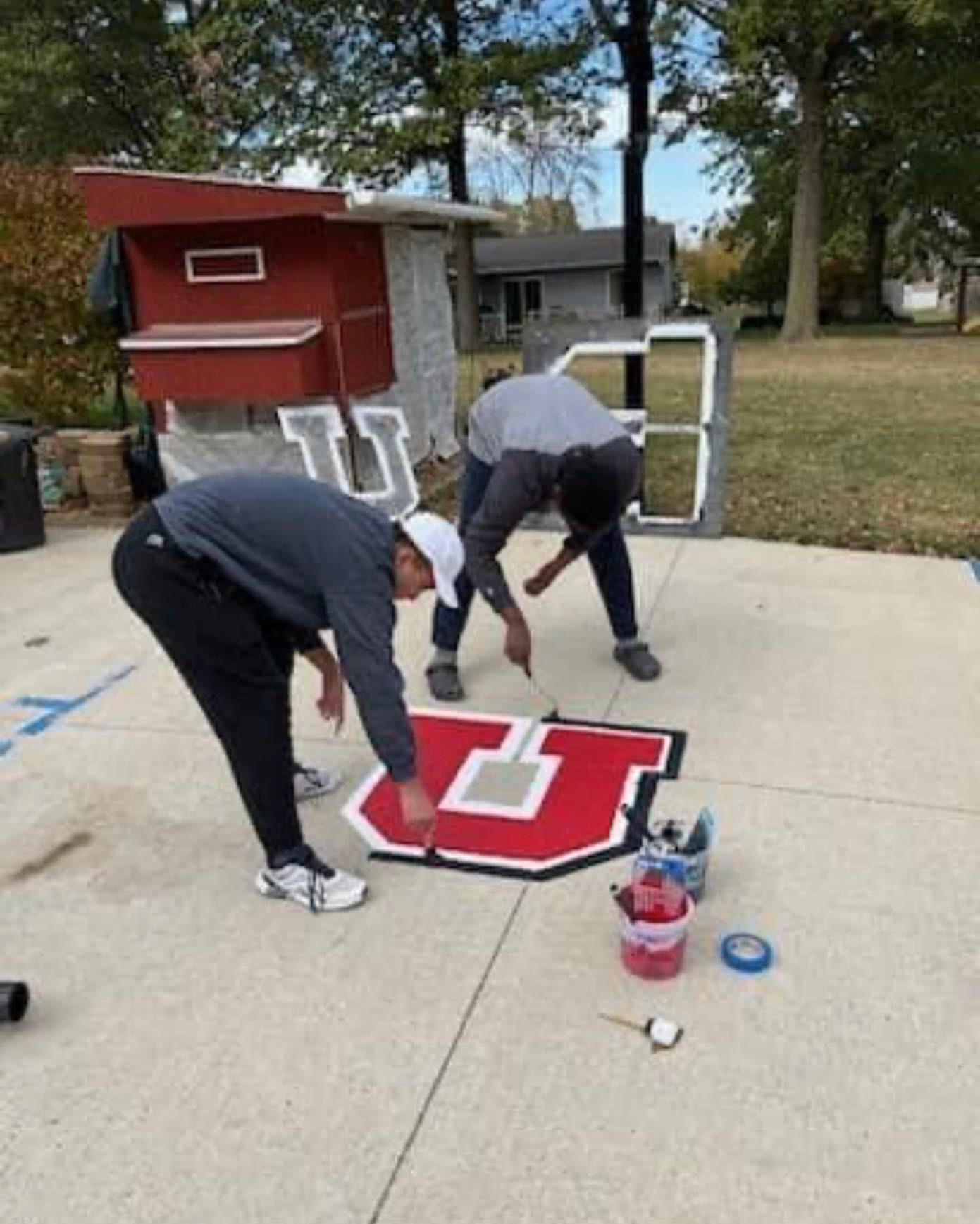Two boys painting a school logo