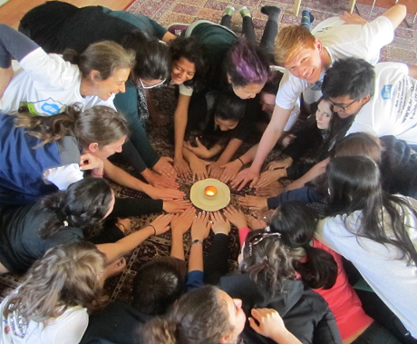 A Group Of Students Putting Their Hands In The Middle Of A Circle