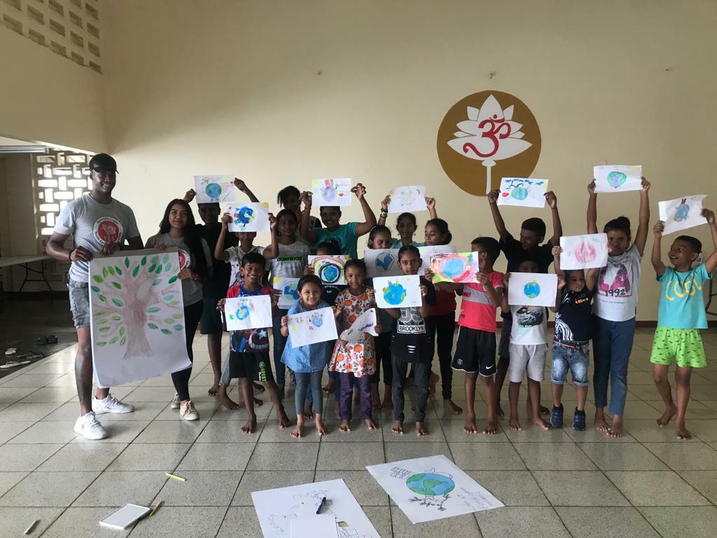 A group of youth holding up drawings of the planet