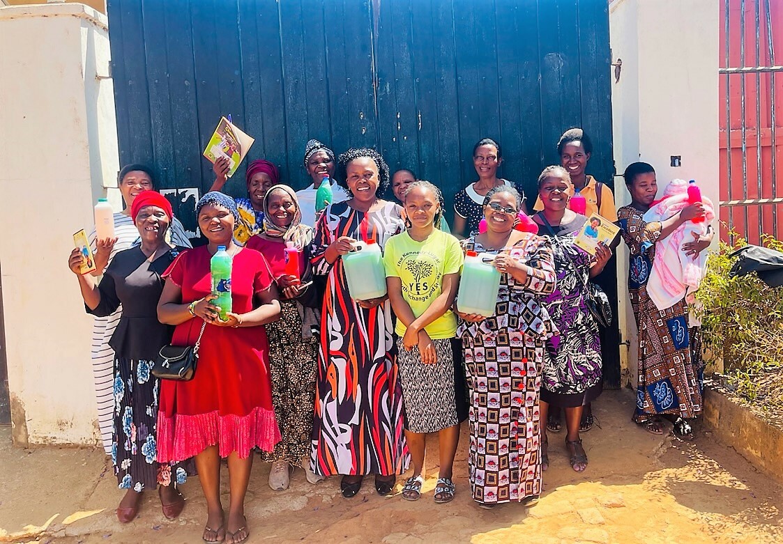 A Group Photo With Women Holding Up The Multipurpose Liquid Soap They Learned To Make Through The Training