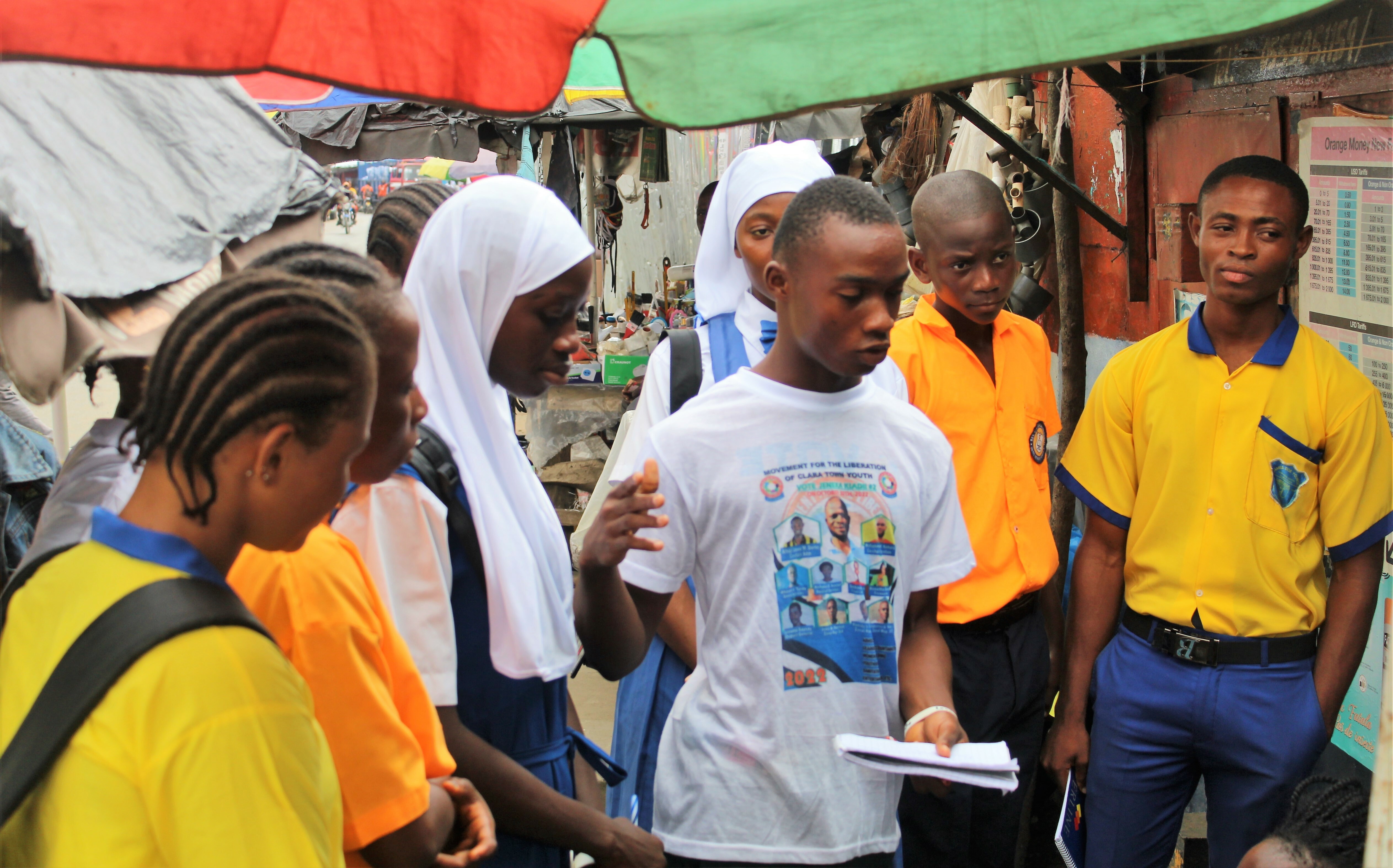 A Participant Is Talking To Shoppers At The Marketer About Ways They Can Reduce The Waste They Generate During Their Day To Day Activities