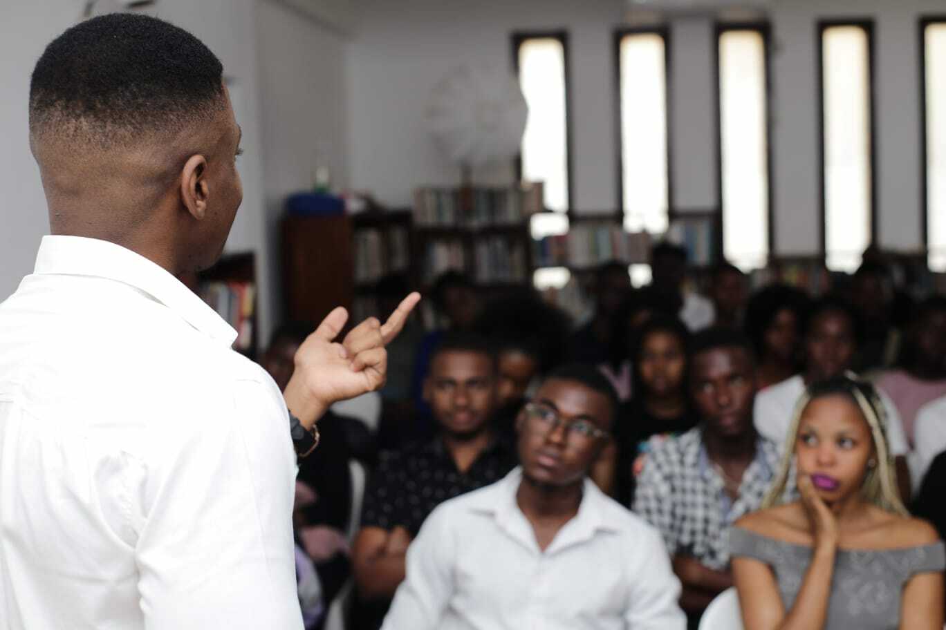 A speaker captured from the back speaking to the youth audience