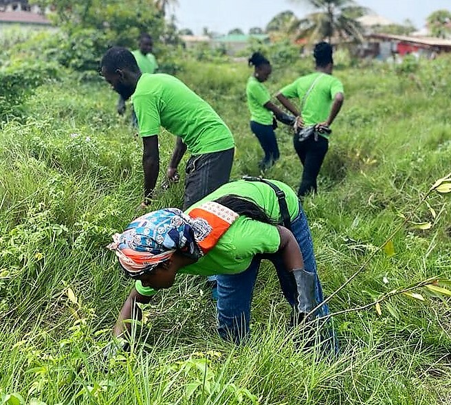 A Volunteer Team In Liberia Works In A Field