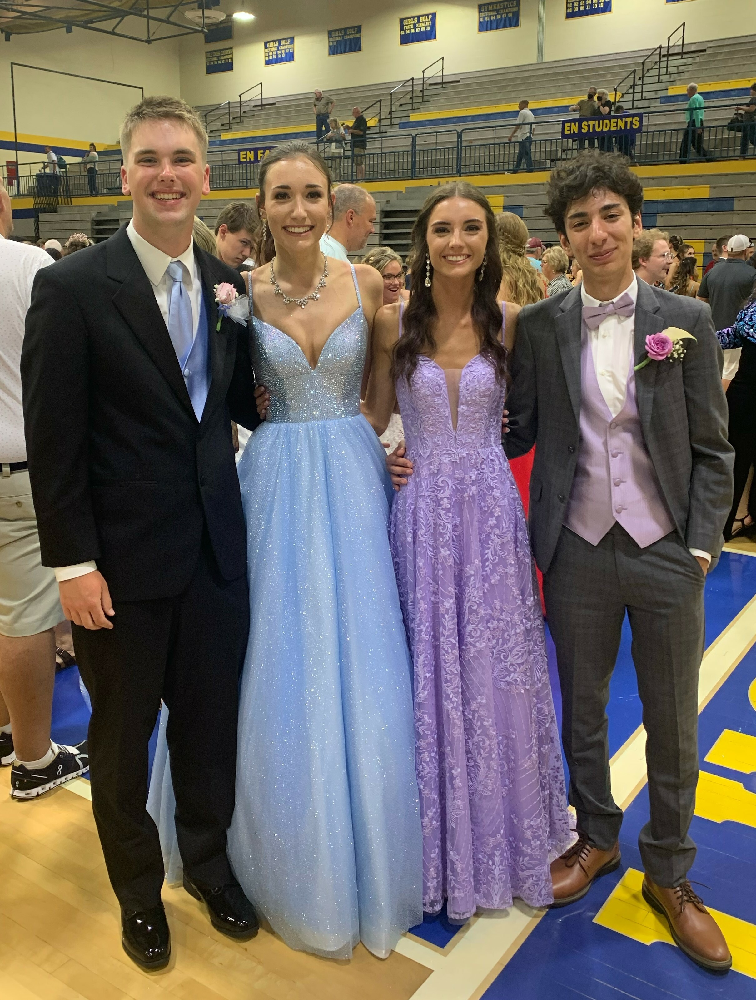 Four high school students, two boys and two girls, pose for a picture in their prom outfits