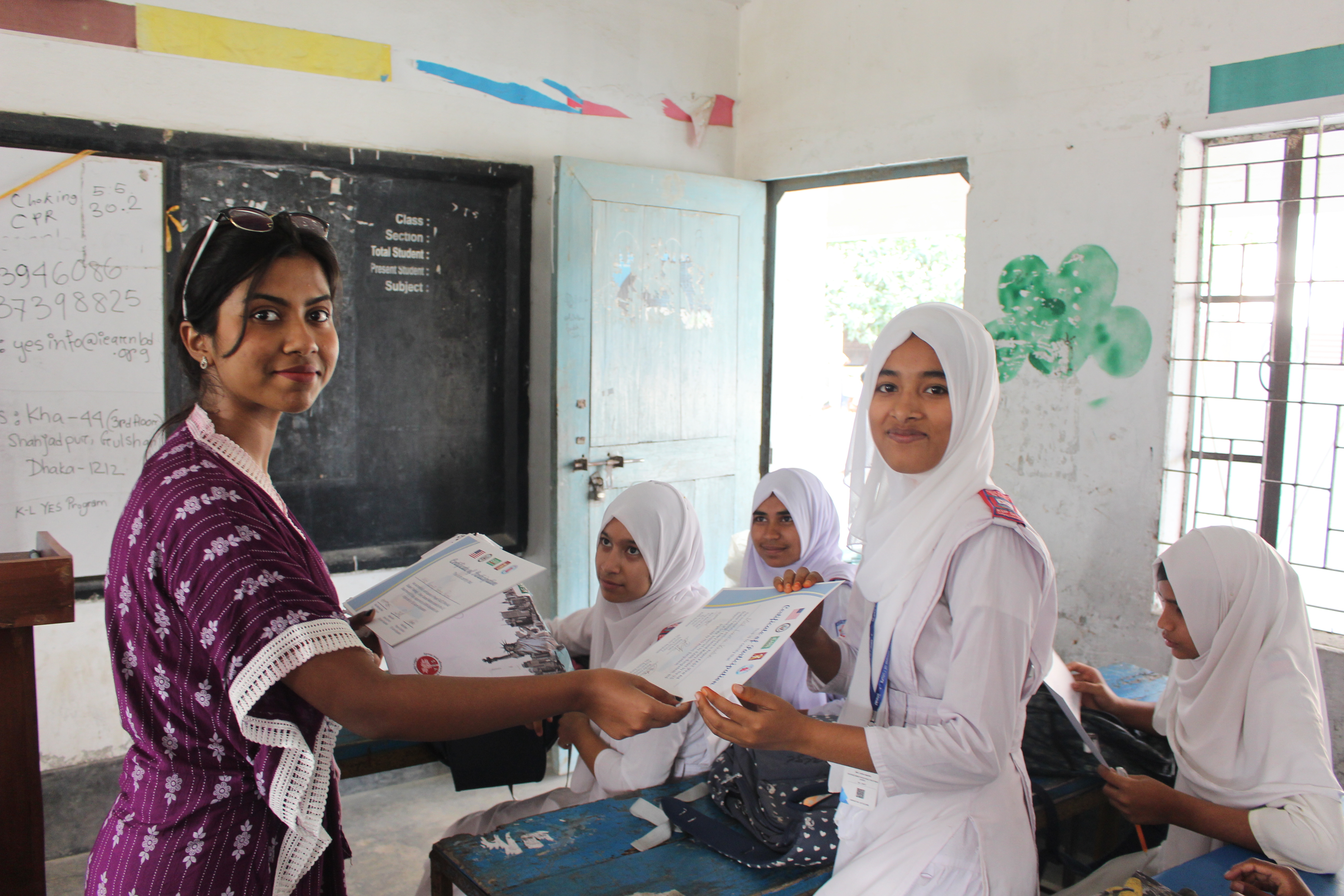An Alumna Presents A Student With A Certificate At A Bangladesh First Aid Training