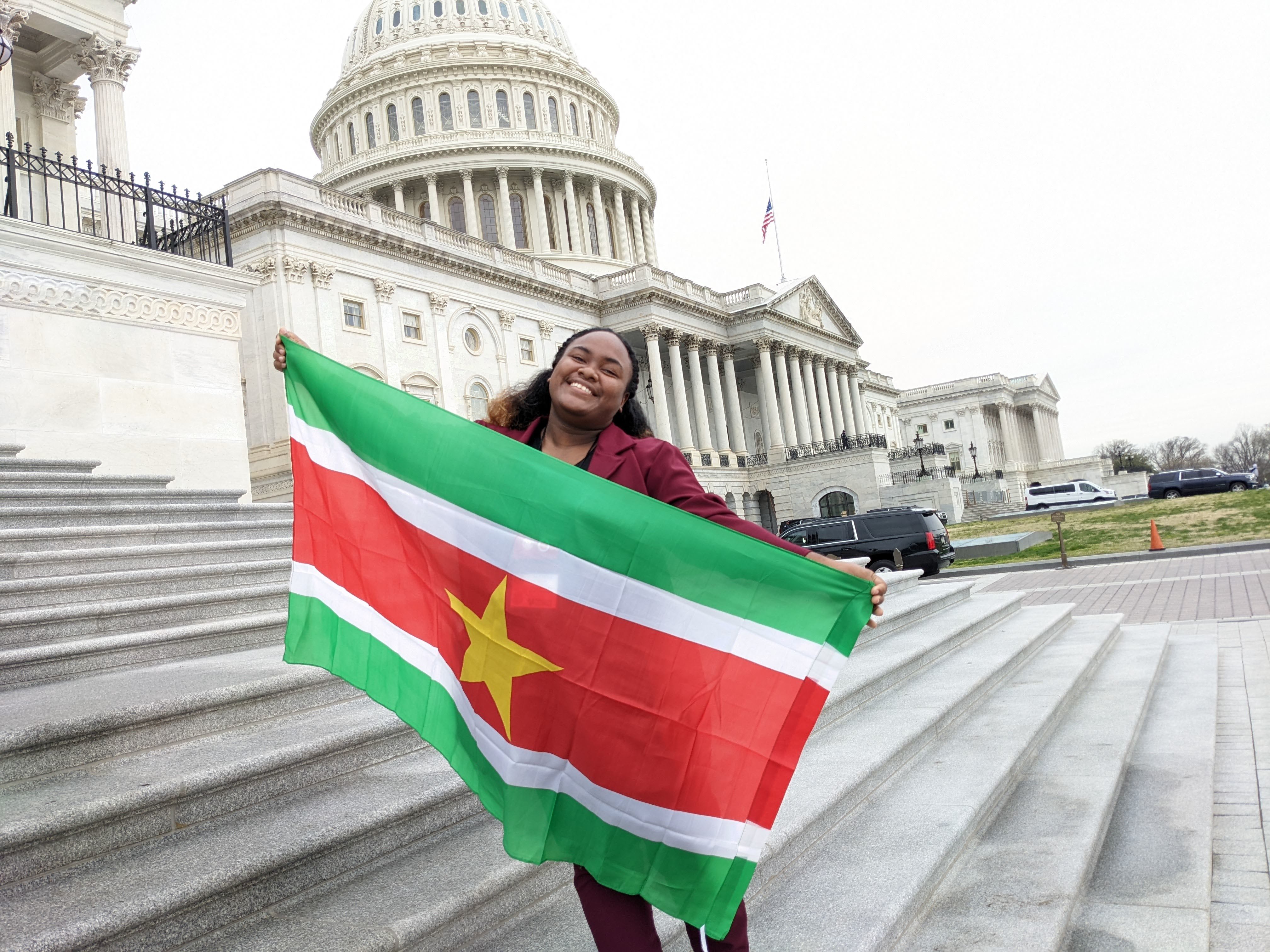 Cheraine Holding The Surinamese Flag In Front Of The Us Capitol