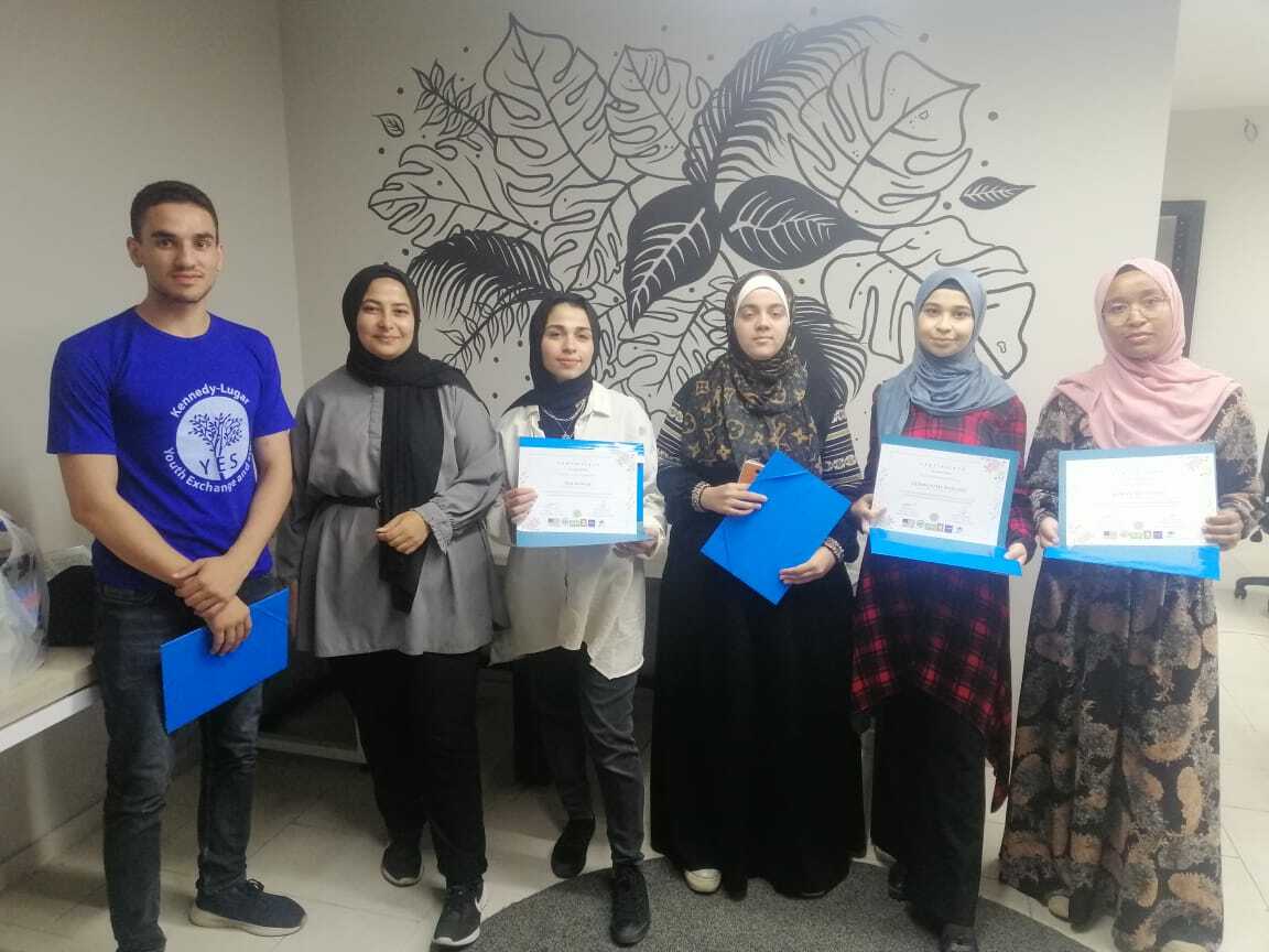 Five Participants And Project Leader Heba Al Saidi Stand In A Line Holding Their Certificates