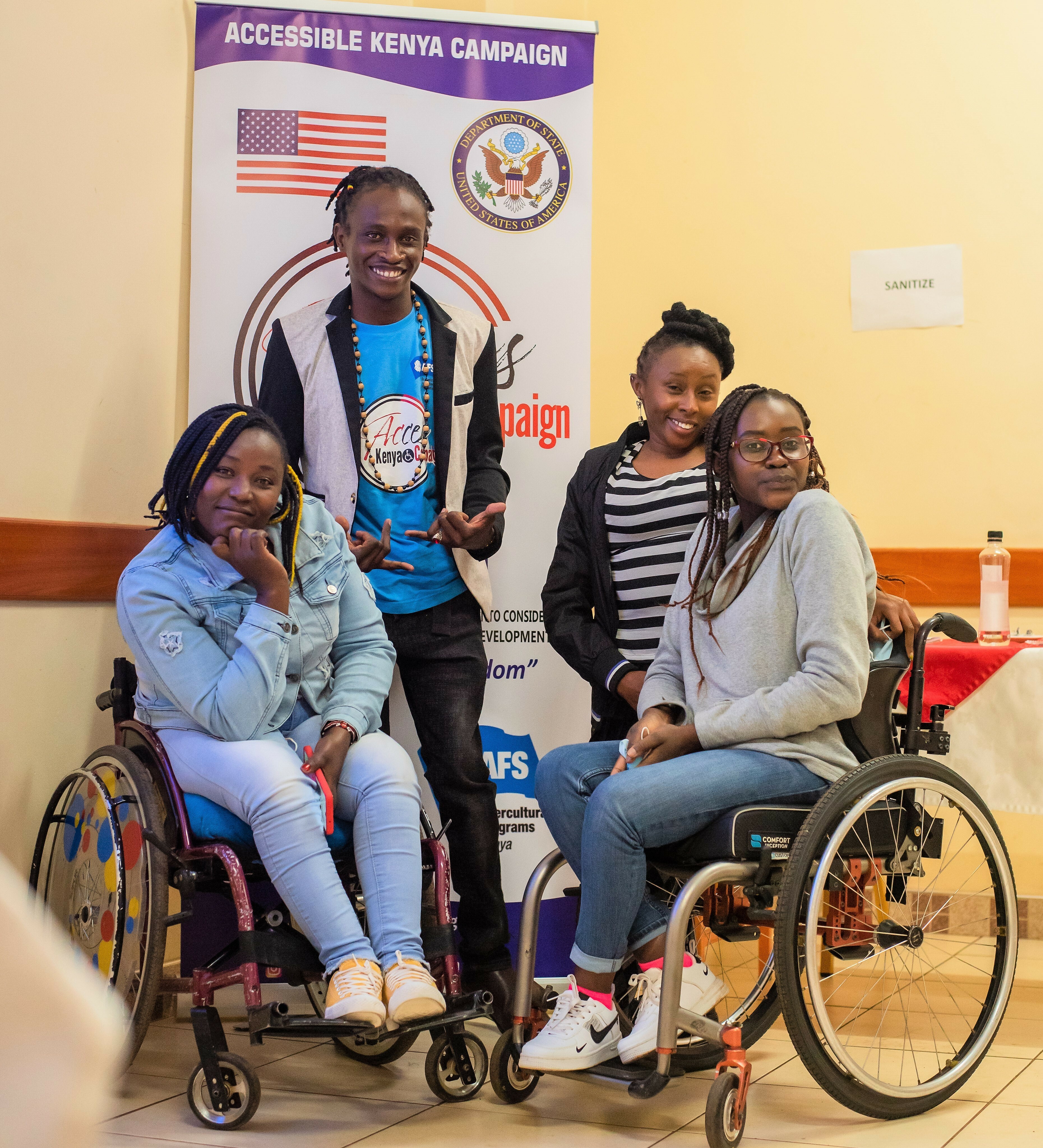 Four Project Team Members Pose In Front Of The Accessible Kenya Banner