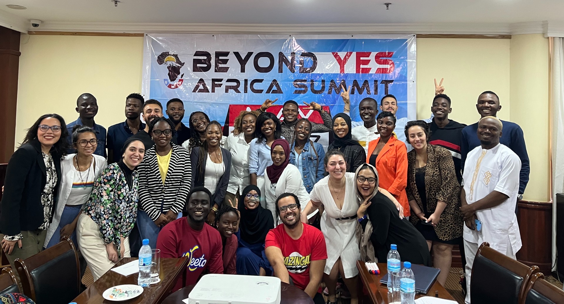 Group photo of the YES alumni in front of a banner that reads "Beyond YES Africa Summit".