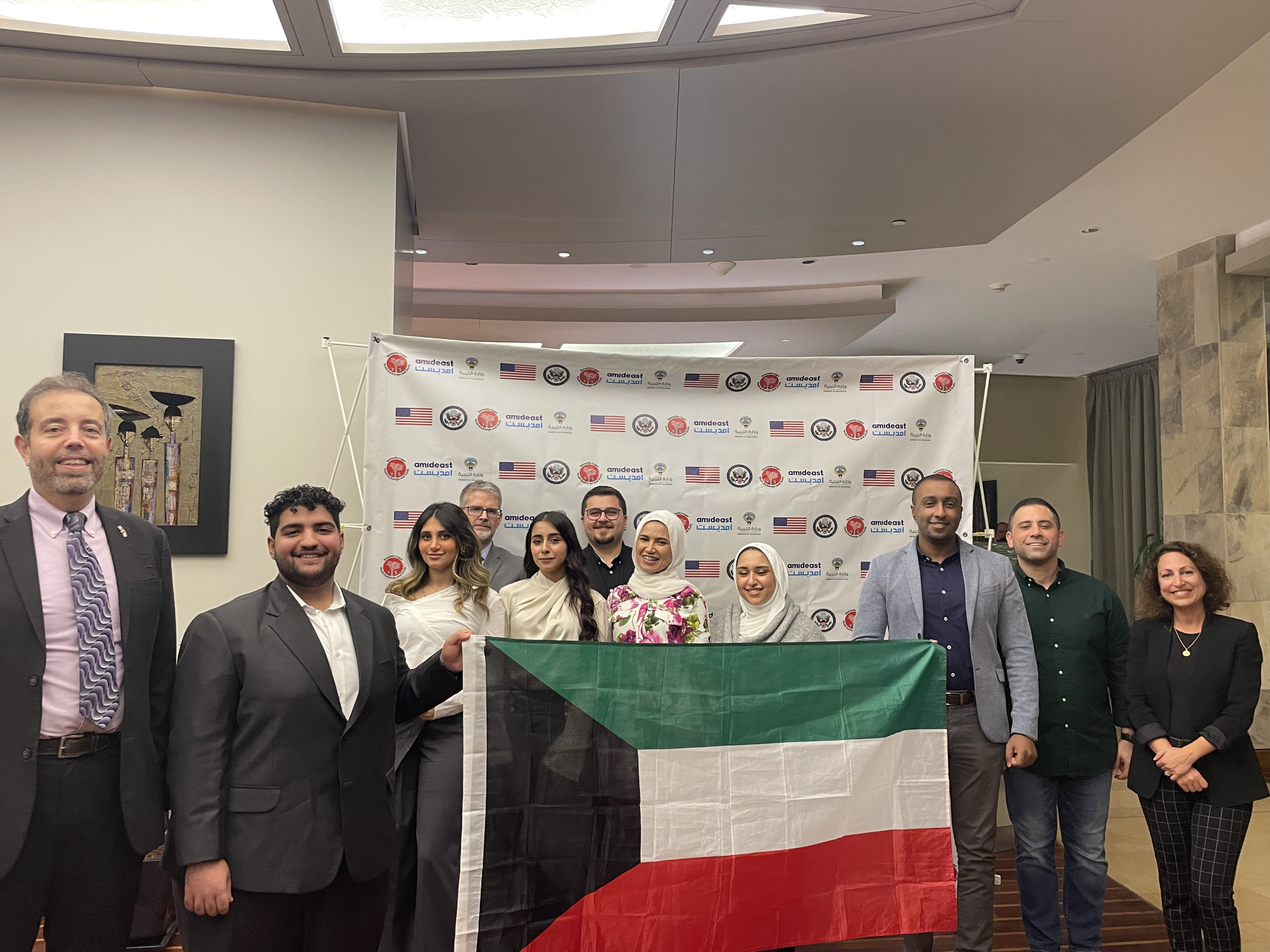 Group of people in business clothes holding the Kuwaiti flag