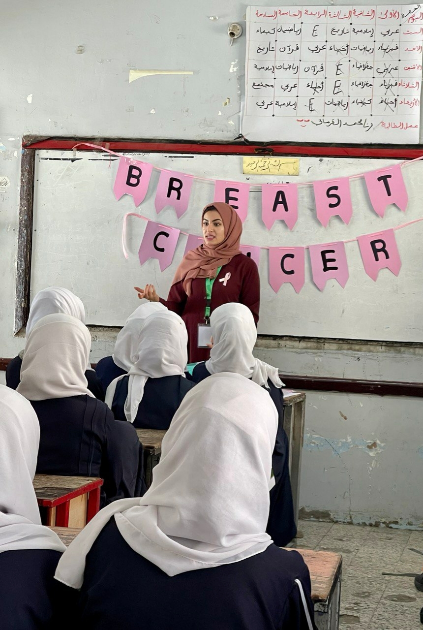 Haya At The Front Of A Room Of Women In Front Of A Breast Cancer Banner