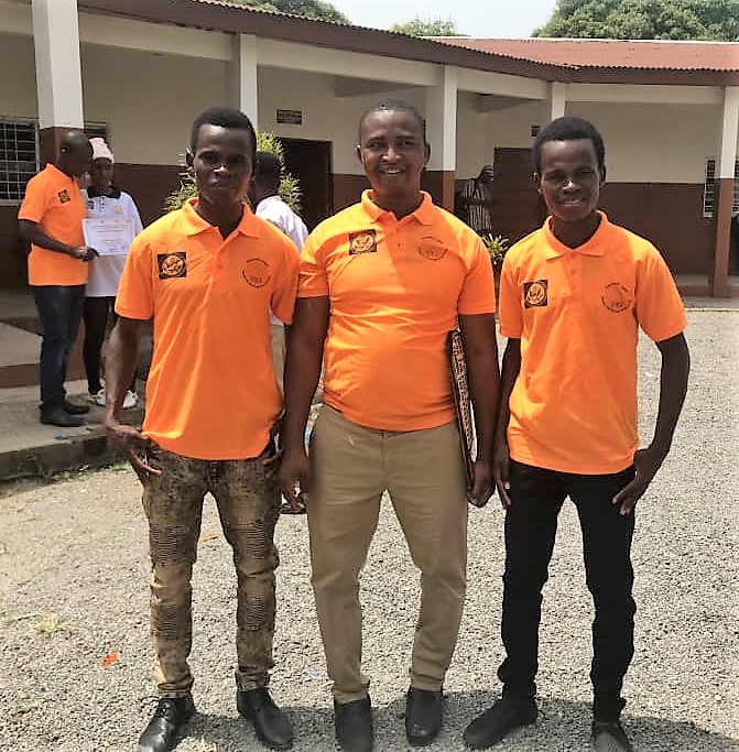 Three young men wearing bright orange shirts stand