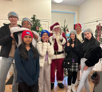 A group of students posing with Santa Claus
