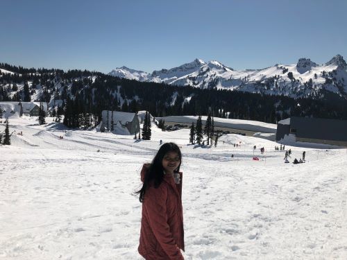 Seema standing on a ski slope with mountains in the background
