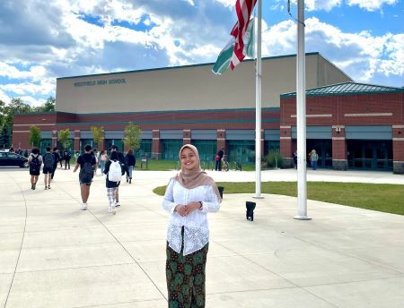 Adinda standing in front of her High School