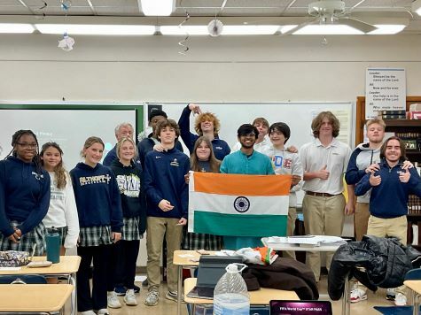 Naityik holding Indian flag poses with a group of his classmates in school classroom