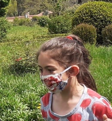 Young girl wears a cloth face mask