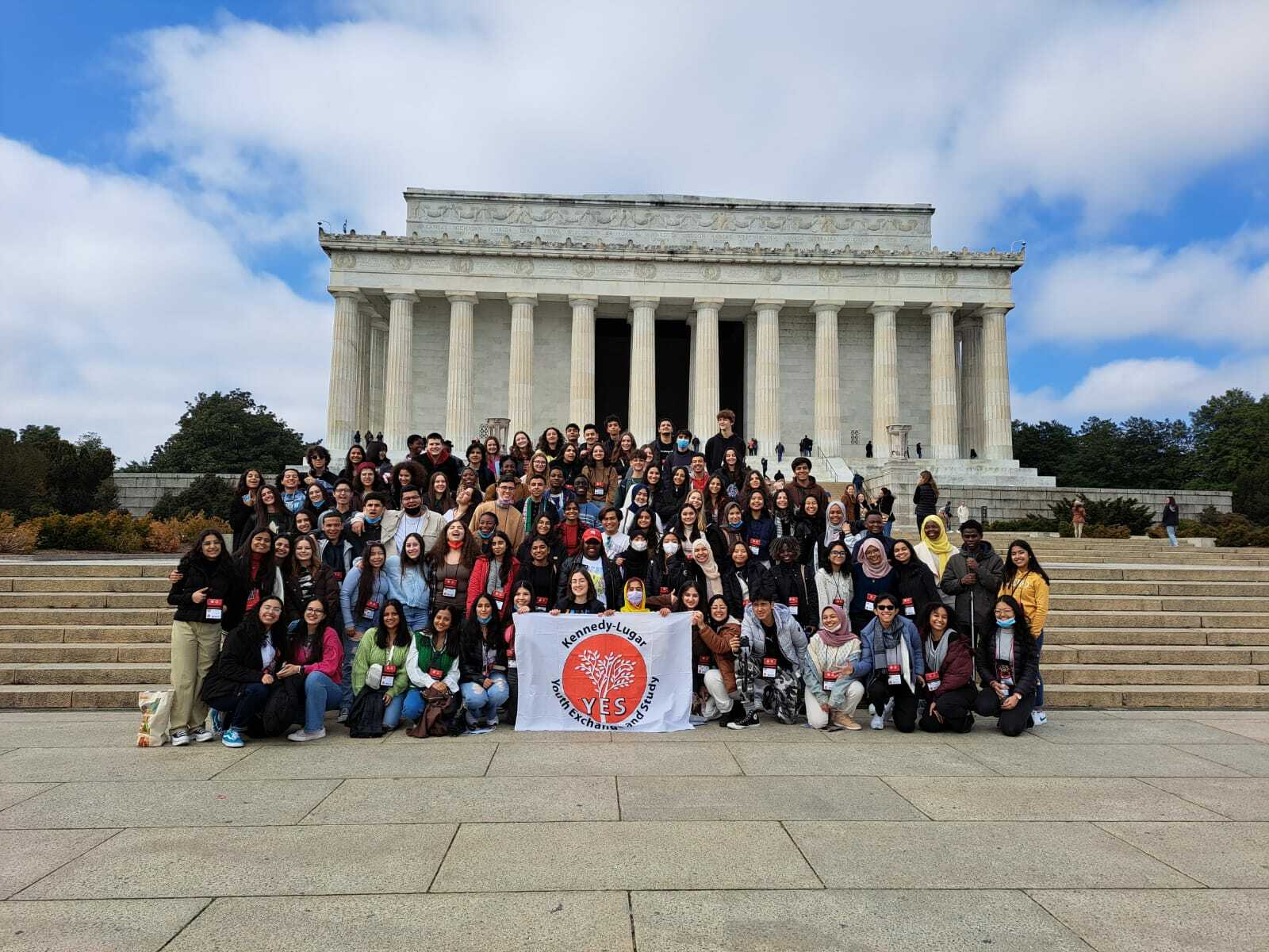 Large Group Of Cew Attendees Posing With The Yes Flag At The Lincoln Memorial