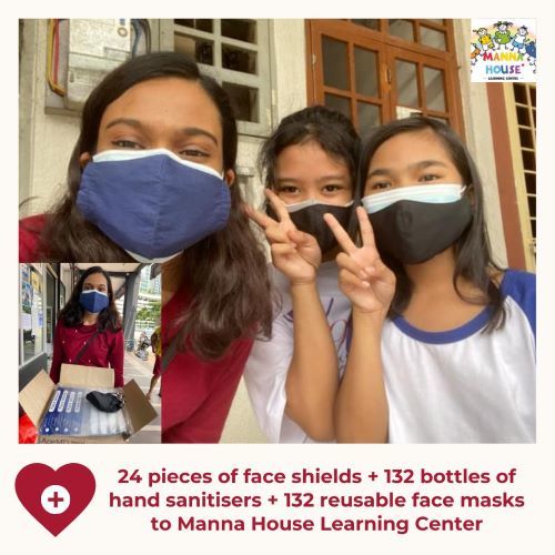 Three young girls wear face masks and give peace signs