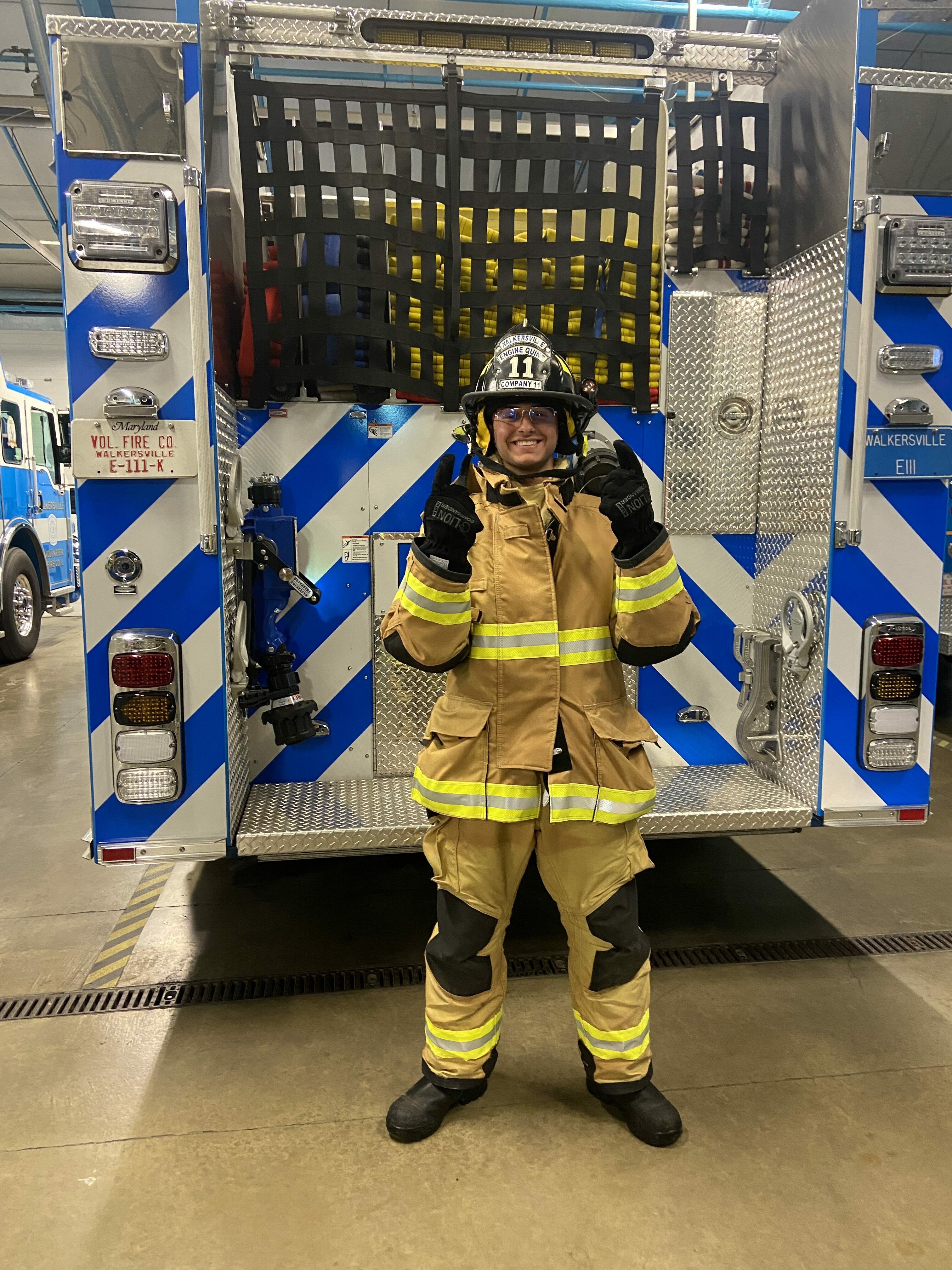 Mohammad Wearing A Firefighter Uniform In Front Of A Fire Truck
