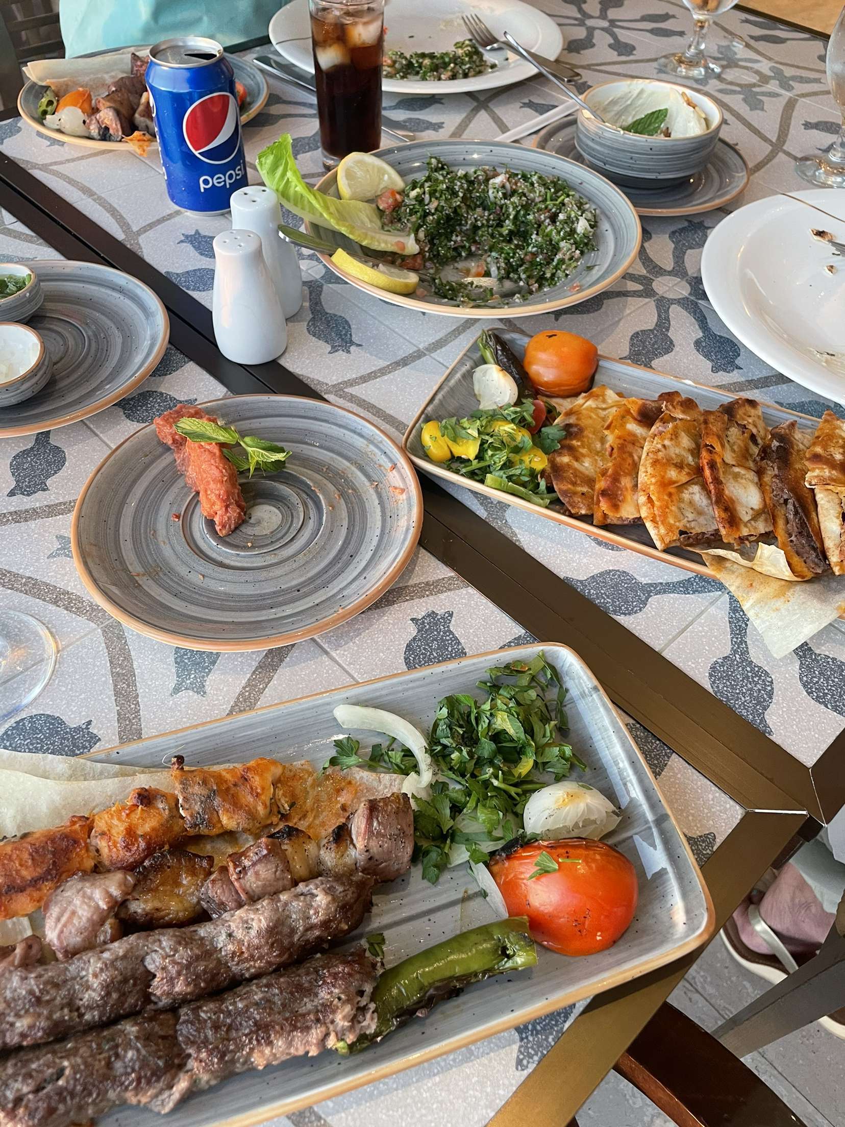a table spread with many colorful middle eastern food dishes