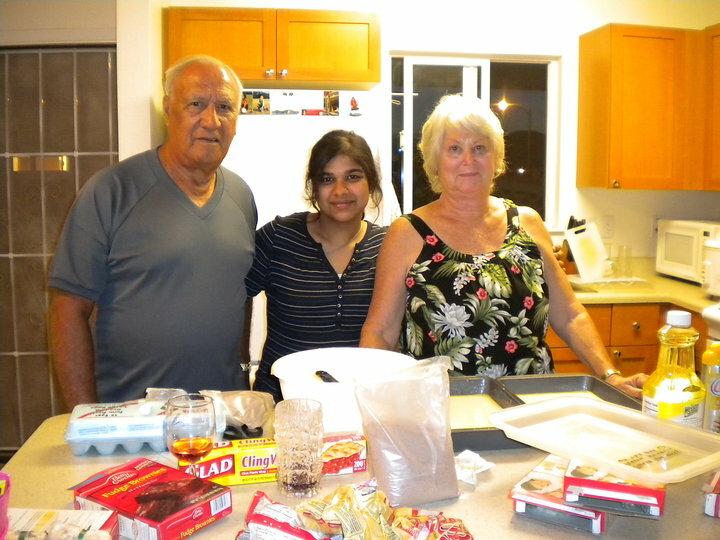 Photo Of Alum Posing With Host Family In A Kitchen