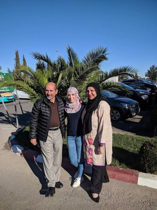 Photo Of Alum With Her Host Family In Front Of Palm Tree